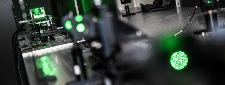 A detail shot of a laser in the lab in dark green colors.
